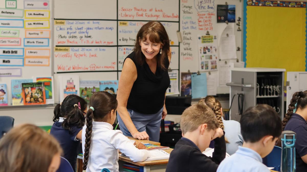 Teacher smiling at her students who sit at their desks