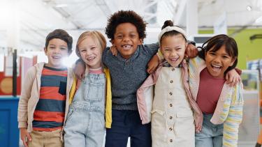 group of diverse children with smiles in school classroom, ready for learning
